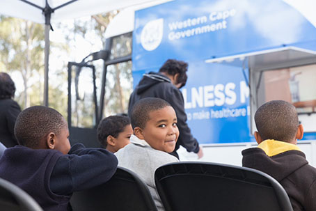 Children waiting to receive healthcare services at a wellness mobile clinic